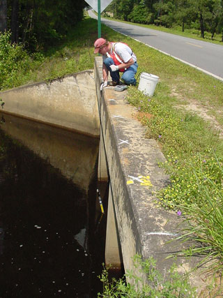 usgs employee collecting water sample